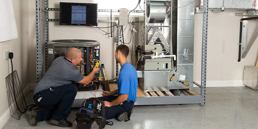 Pinellas Comfort Systems techs working together on inspecting air conditioner