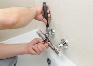 plumber fixing bath faucet 